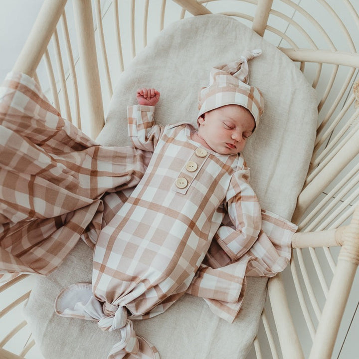 Little baby wearing a soft brown knotted gown from snuggly jacks