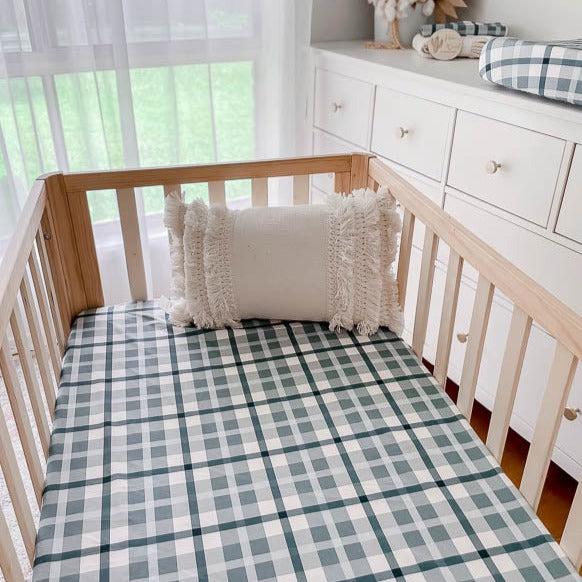 Modern nursery with snuggly jacks burp clothes, change pad cover and fitted crib sheet all in a blue plaid pattern.