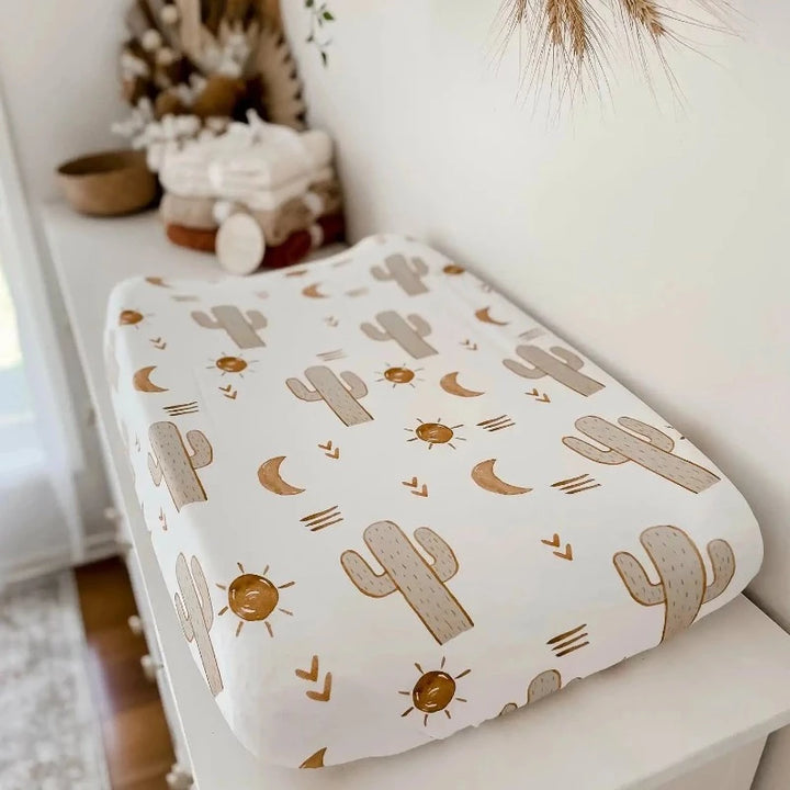 White pine change table with cotton knitted blankets in the background and a cotton change mat cover in the four ground.