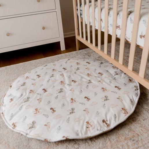 Cotton Playmat with a green, Brown and white pattern set out on a floor rug in a nursery 