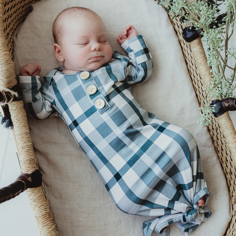 A little bundle of join wearing a snuggly jacks canada knotted gown resting in a moses basket