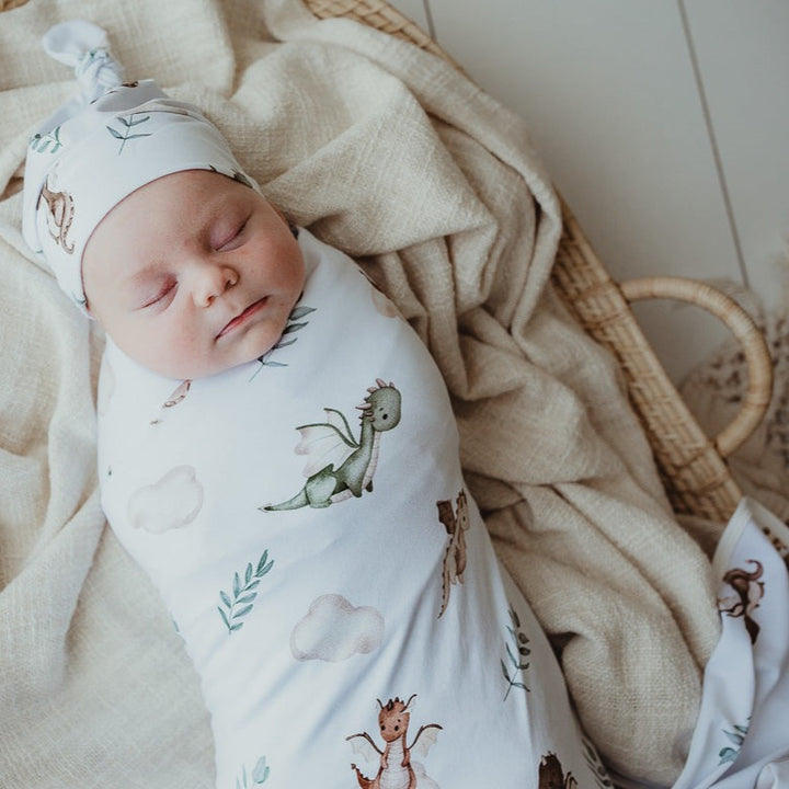 Sweet young boy all wrapped up in a stretch wrap from snuggly jacks australia wearing a matching dragon print beanie