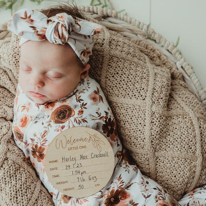 Baby all snug on a knitted cotton blanket with a snuggly jacks australia announcement disc.