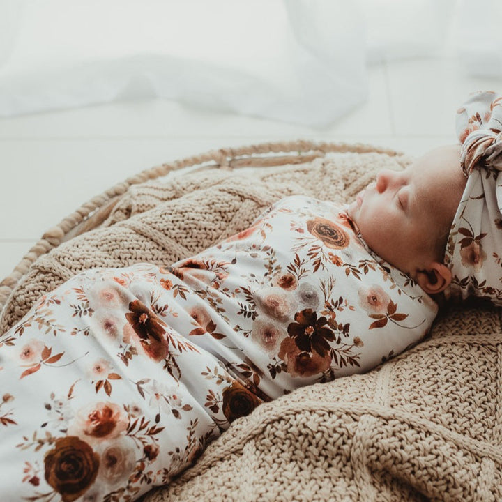 Bright white light cascading in on a cute baby swaddled and laying on a soft cotton knitted blanket